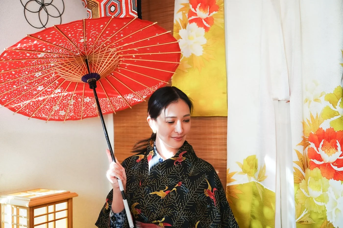 A guest in kimono with a red umbrella